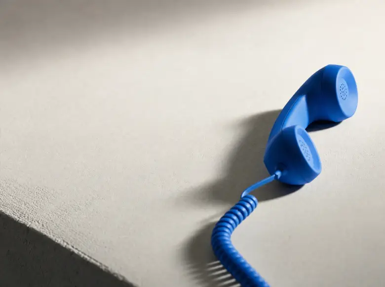 A blue phone receiver in natural daylight